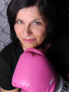 Nadine Vogel close-up facial image, pink boxing-glove held to chin